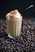 Ein Glas Latte Macchiato auf Kaffeebohnen