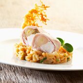 Rabbit roulade with chicory on a bed of risotto garnished with a Parmesan wafer