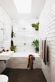 White subway tiles and house plants in narrow bathroom