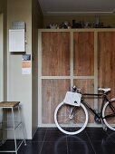 Fahrrad im Hauswirtschaftsraum vor Einbauschrank mit schlichten Eiche-Türen