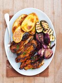 Grilled pork ribs with courgette, onion and baked potatoes