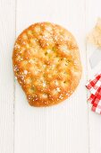 A whole focaccia on a wooden surface