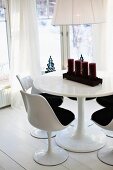 Tulip-Stühle an rundem Tisch mit Adventskerzen im Erkerbereich