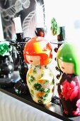 Japanese Kokeshi dolls in bright colours and black candlesticks on sunny windowsill