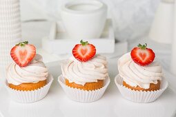 Three strawberry cupcakes topped with buttercream