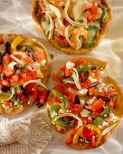 Mini pizzas with peppers, olives and feta (seen from above)