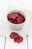 Beetroot chips in a bowl and on a cloth