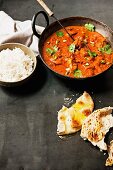 Butter chicken (India chicken curry) served with rice and naan bread