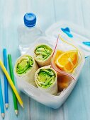 A healthy lunch for school with wraps, fruit and water
