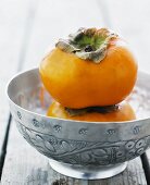 Two persimmons stacked on top of each other