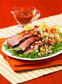 Three slices of roast beef with vegetables and wheat on a bed of rocket