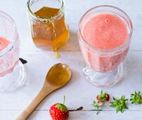 A strawberry smoothie made with pineapple and honey