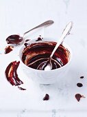 The remains of chocolate glaze in a bowl with a spoon
