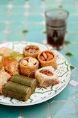 Various baklava and Turkish nut cakes on a ceramic plate