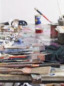 Painter's utensils on long wooden table in artist's studio