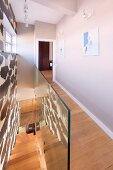 House with modern stairwell, narrow landing, wooden floor and glass balustrade