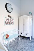 Wooden bench painted pastel blue next to white farmhouse cupboard