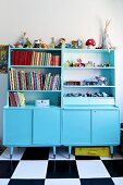 Dressers painted pale blue in child's bedroom with chequered floor