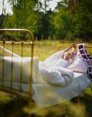 Child waking up in bed in meadow