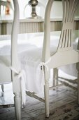 White-painted wooden chairs seat covers over seat cushions