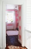 View into pink, child's bedroom with heart and star patterns on walls