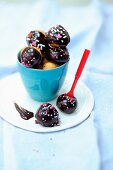 Chocolate covered profiteroles with sugar sprinkles
