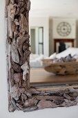 Detail of mirror with driftwood frame and reflection of interior