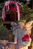 Beleuchtete Stein Engelfigur vor Efeukranz im Garten