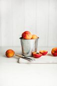 Apricots in a metal container and next to it, one halved