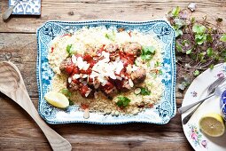 Moroccan lamb meatballs on a bed of couscous with tomato sauce, yoghurt and almonds