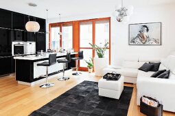 Offener Wohnraum mit Frühstücksbar und Sofalandschaft im schwarz-weiss Design