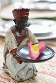 Small ceramic figurine holding scented petals