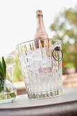 Vase and wine bottle in ice bucket on outdoor table