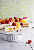 Cheesecake with peaches, raspberries and grated chocolate