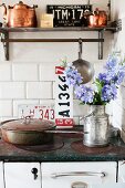 Wall-mounted shelf above nostalgic cooker and copper pans in Swedish vintage kitchen