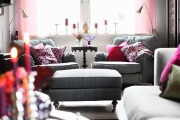 Country-house-style room with comfortable, grey striped armchairs, ottoman and reading lamps