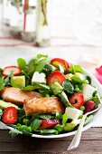 Salmon fillet on a strawberry and mint salad