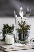 Salt, thyme, rosemary and cutlery in jars