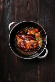 Braised pork knuckles with carrots in a saucepan