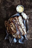Rustic olive bread, sliced, with butter
