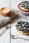 Blackberry tartlets with confectioner's cream and icing sugar