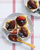 Pastry dishes filled with dark chocolate mousse, fresh strawberries and blueberries