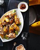 Fried Mexican corn cobs with grated cheese, sumac and a pepper dip