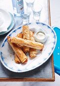 Stuffed puff pastry rolls served with ouzo and aioli (Greece)