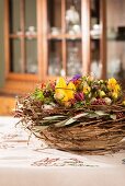 Tischdekoration für Ostern mit Frühlingsblumen & Weidenzweigen