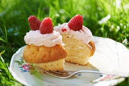 A cupcake topped with buttercream and raspberries