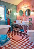 Badezimmer mit freistehender Badewanne auf rot-weißem Schachbrettmusterboden und Waschbecken auf verschnörkeltem Metalltisch