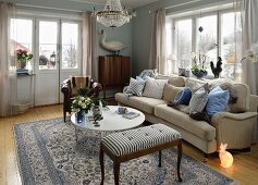 Traditional living room with pale sofa, many scatter cushions and bunny-shaped floor lamp