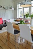 Retro lamp above table in dining room with white, wood-clad walls