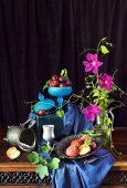 An arrangement of peaches, plums and purple clematis